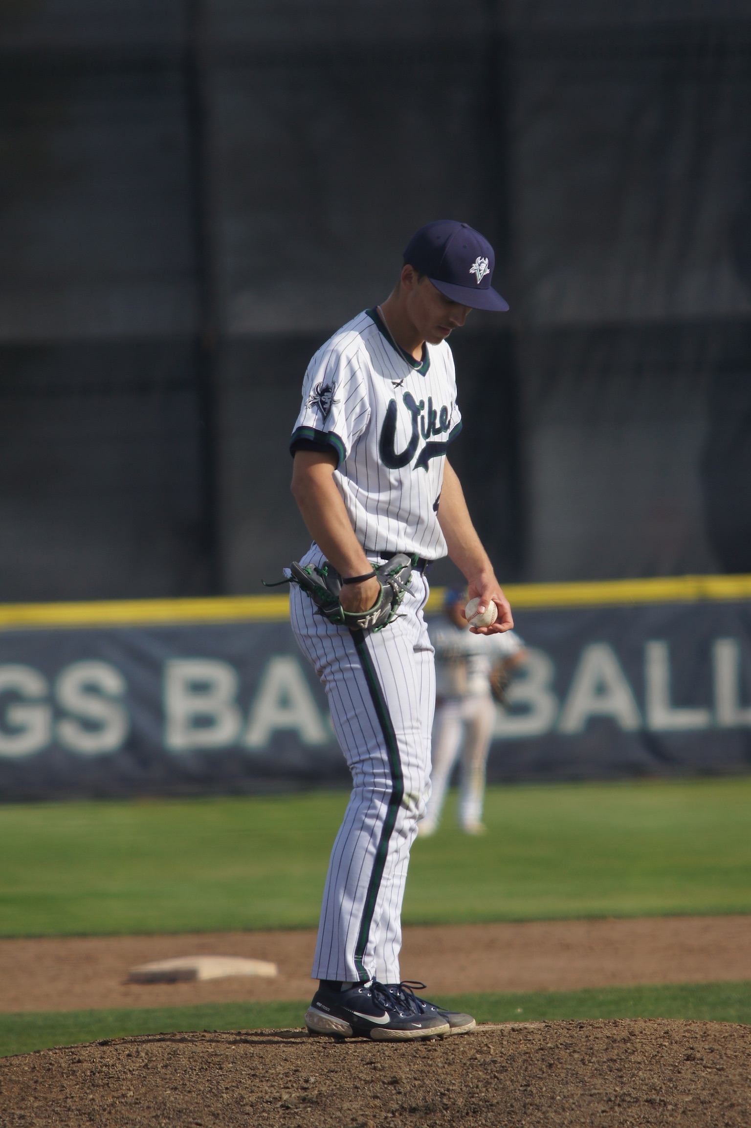 Talan standing on the pitcher’s mound with a baseball and glove.